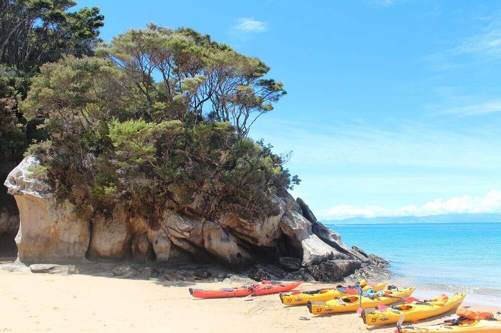 Kayaks on the beach in January in New Zealand's summer